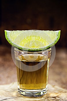 glass of alcoholic drink with lemon, distilled from sugar cane