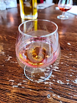 A glass of amaretto with soft background on a wooden table photo