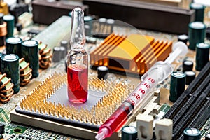 Glass ampoule with red medicine with syringe on socket with cpu chip.