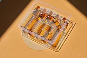 Glass ampoules on a beige orange background.