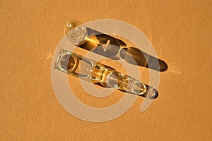 Glass ampoules on a beige orange background.