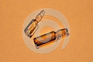 Glass ampoules on a beige orange background.