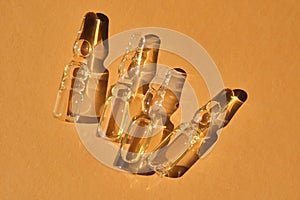 Glass ampoules on a beige orange background.