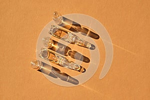 Glass ampoules on a beige orange background.