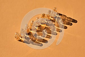 Glass ampoules on a beige orange background.