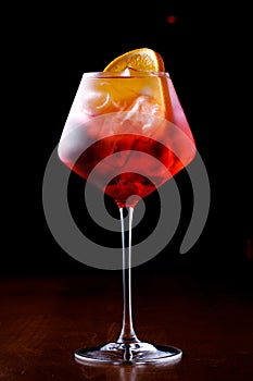 Glass of aperol spritz cocktail on a black background close up