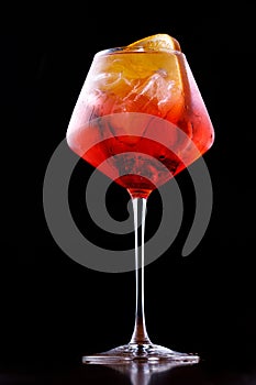 Glass of aperol spritz cocktail on a black background close up