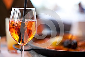 Glass of aperol spritz cocktail long drink close up, summer fresh appetizer, evening meal, dinner