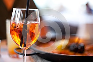 Glass of aperol spritz cocktail long drink close up, summer fresh appetizer, evening meal, dinner photo