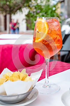 Glass of aperol spritz cocktail on outside table on sunny day