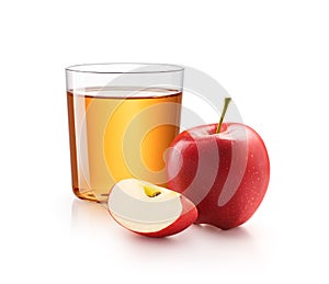 A glass of apple juice with red apples