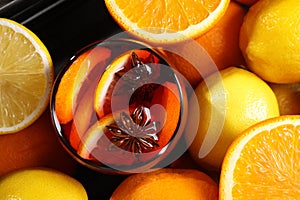 Glass of aromatic punch drink and fresh citrus fruits on table, flat lay