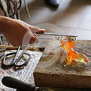 Glass Artist in her workshop making glassware