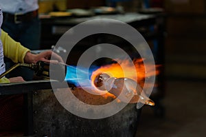 Glass Artist in her workshop making glassware