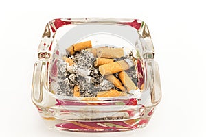 Glass ashtray with cigarette butts, isolated on white
