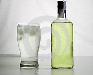 Glass with backlit gin and tonic and bottle of gin