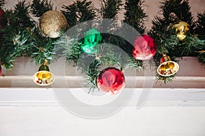 glass ball and decorations on Christmas tree.Garland with lights and red-green, gold balls on a white background