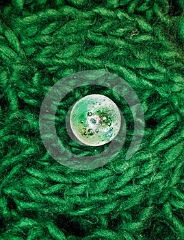 Glass ball on green scarf