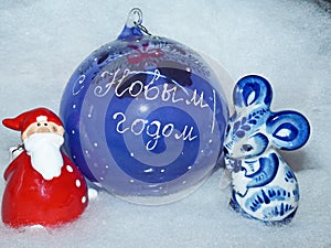 Glass ball with the inscription in Russian `Happy New Year`, Santa Claus and symbol of the New Year 2020 is a white rat