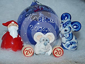 Glass ball with the inscription in Russian `Happy New Year`, Santa Claus, symbol of the New Year 2020 is a white rat