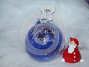 Glass ball with the inscription in Russian `Happy New Year`, Santa Claus and symbol of the New Year 2020 is a white rat mouse