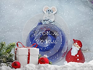 Glass ball with the inscription in Russian `Happy New Year`, Santa Claus and symbol of the New Year is a white rat mouse