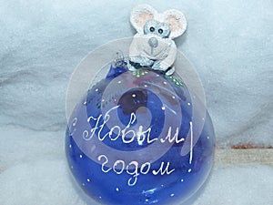 Glass ball with the inscription in Russian `Happy New Year`and symbol of the New Year 2020 is a white rat mouse