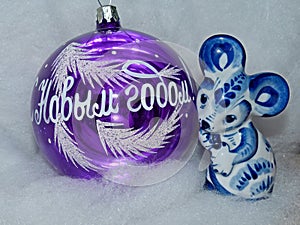 Glass ball with the inscription in Russian `Happy New Year` and symbol of the New Year 2020 is a white rat mouse