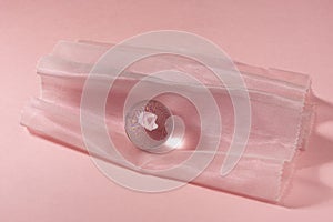 Glass ball on pink organza textile background.