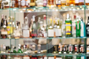 Glass bar counter with blurred shelves with bottle on the background