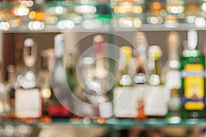 Glass bar counter with blurred shelves with bottle on the background.