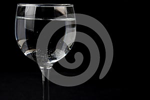 glass beaker with clear liquid isolated on black background