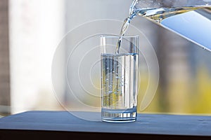 A glass beaker is filled with clean water in the open air. Summer sunny day