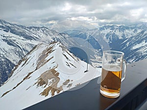 A glass of beer above a dreamy mountain valley