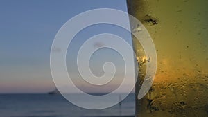 Glass of beer against blurred ship in the sea background