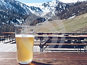 Glass of beer with alps mountain in the background