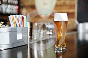 Glass of beer on bar counter in cafe
