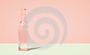 Glass beer bottle on horizontally divided bi-color retro pastel pink and green color background