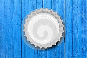 Glass beer bottle cap isolated on blue wooden background, top view. 3d illustration