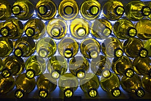 Glass beer bottles lie in rows, necks on camera