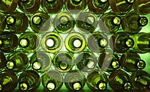 Glass beer bottles lie in rows, necks on camera, shallow depth of sharp