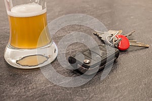 Glass of Beer and car key on grey table