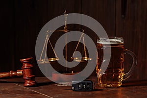 Glass of beer, car keys and wooden judge gavel in a notary office. Alcohol and law concept