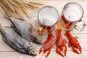 Glass beer with crawfish and dried fish on light wooden background. Beer brewery concept. Beer background. top view