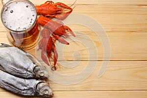 Glass beer with crawfish and dried fish on light wooden background. Beer brewery concept. Beer background. top view with copy