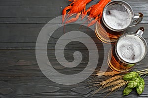 Glass beer with crawfish, hop cones and wheat ears on dark wooden background. Beer brewery concept. Beer background. top view