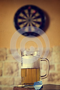 Glass of beer and dartboard, filtered