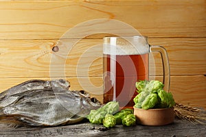 Glass beer with dried fish on light wooden background. Beer brewery concept. Beer background.