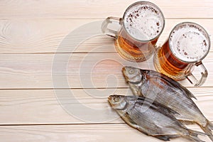 Glass beer with dried fish on light wooden background. Beer brewery concept. Beer background. top view with copy space