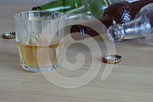 A glass of beer  empty bottles and corks on the table